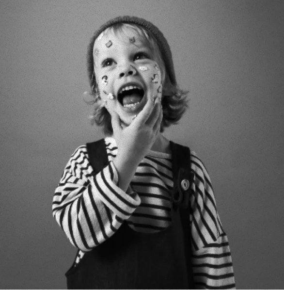 A child in a striped top and comfortable overalls